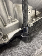 Close-up of the fill tube fitting and braided line installed on a Bowler billet 8HP transmission pan